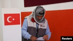 Чоловік тримає бюлетень для голосування на виборчій дільниці під час місцевих виборів у Діярбакирі, Туреччина, 31 березня 2024 року