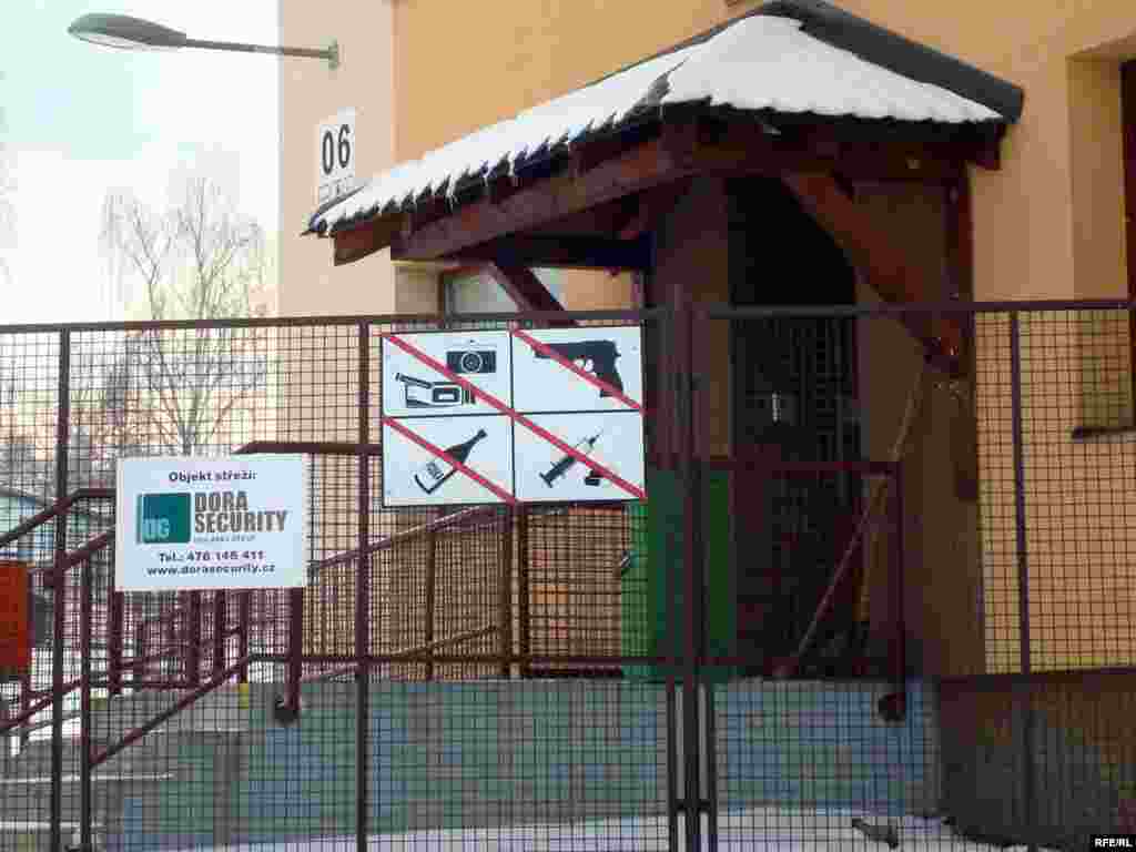 Вход в приемный центр лагеря беженцев в чешской деревне Вышни Лхоты.  - Ограждение приемного центра чешского лагеря беженцев в деревне Вышни Лхоты. 1 февраля 2009 года. 