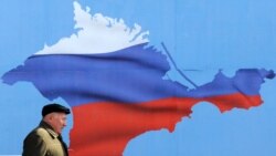 Ukraine -- A man walks past a poster depicting Crimea in the colors of the Russian flag, in Sevastopol, March 11, 2014