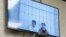 Salekh Magamadov and Ismail Isayev are seen on a video monitor in a courtroom in Achkhoi-Martan.