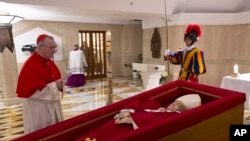 Državni sekretar Vatikana kardinal Pietro Parolin, lijevo, moli se ispred tijela pape Franje položenog u njegovoj privatnoj kapeli u Vatikanu, ponedjeljak, 21. aprila 2025. 