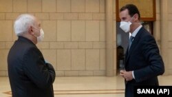 Голова МЗС Ірані Джавад Заріф (ліворуч) та президент Сирії Башар аль-Асад (праворуч) під час зустрічі в Дамаску, 20 квітня 2020 року