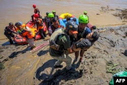 Cпасатели эвакуируют сельского жителя, провинция Ачех, Индонезия, 29 ноября 2025 года