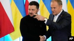 Прем’єр-міністр Польщі Дональд Туск (праворуч) тисне руку президента України Володимира Зеленського на спільній пресконференції у Варшаві, Польща, 15 січня 2025 року