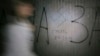 A woman walks past a swastika and the inscription "Death to Jews" painted on a wall in an underpass in Kyiv. 