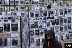 Чоловік іде повз виставку фото білоруських політв’язнів. Центр Варшави, 18 травня 2025 року