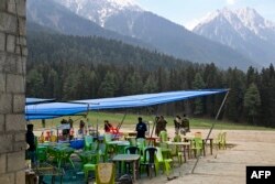 Служители по сигурността проверяват мястото след нападението, докато столовете на сергиите за храна са празни в Пахалгам, на около 90 км от Шринагар, на 23 април 2025 г.