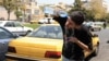 An Iranian taxi driver cools down by splashing water on his face on a street amid soaring temperatures in Tehran on July 22.
