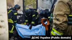 Четверо людей загинули на Київщині і двоє у Києві внаслідок російської повітряної атаки. На фото: рятувальники виносять тіло загиблої людини. Київщина, ранок 22 жовтня 2025 року 