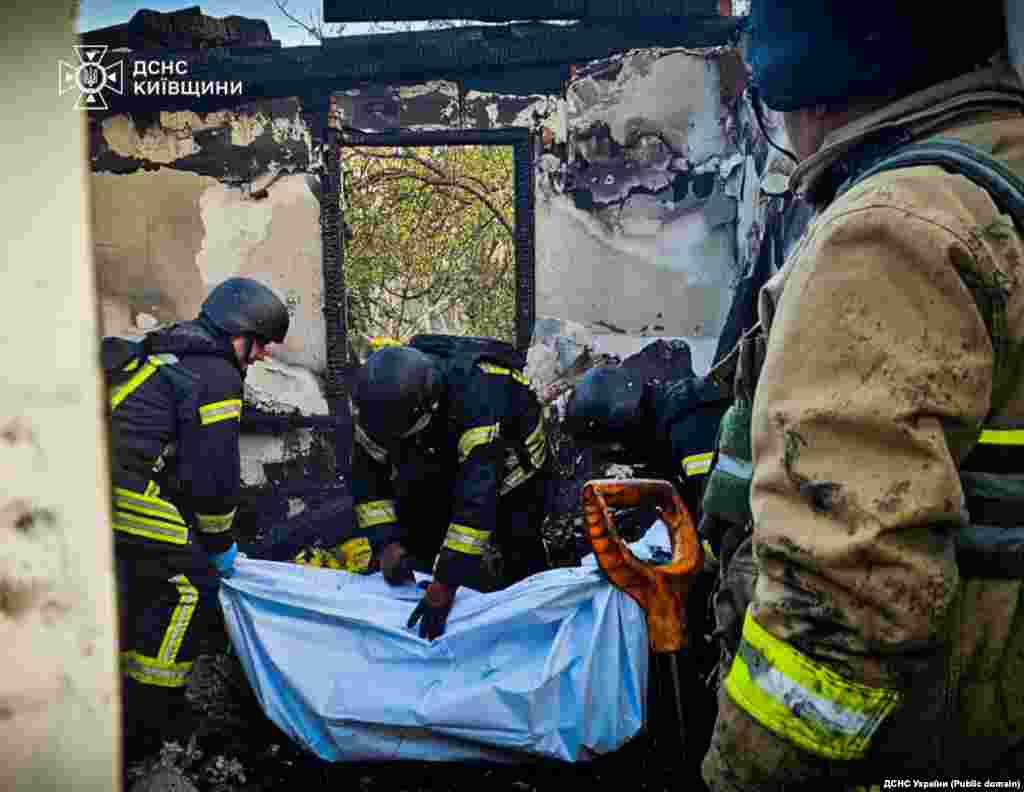 Рятувальники дістають з-під завалів зруйнованого будинку тіло загиблої внаслідок російської атаки.У селі Погреби на Київщині загинули Антоніна Зайченко 1987 року народження, її донька Аделіна, який було шість місяців та 12-річна племінниця Анастасія