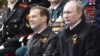 Orsýetiň prezidenti Dmitriý Medwedew (çepde) we premýer-ministr Wladimir Putin Moskwanyň Gyzyl meýdançasynda harby parada tomaşa edýär, 2011-nji ýylyň 9-njy maýy.