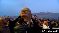 Жители Дамаска празднуют падение режима Башара Асада. В руках у них - голова статуи Хафеза Асада, отца и предшественника свергнутого диктатора