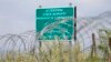 Georgia -- A warning sign is pictured behind a wire barricade erected by Russian and South Ossetian troops along Georgia's de-facto border with its breakaway region of South Ossetia in the village of Khurvaleti, July 14, 2015