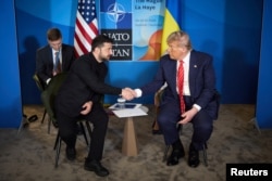 Президент США Дональд Трамп і президент України Володимир Зеленський тиснуть один одному руки під час зустрічі на полях саміту НАТО. Гаага, Нідерланди, 25 червня 2025 року