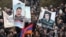 Armenia -- Demonstrators hold up pictures of jailed opposition members Aram Bareghamian (R) and Sasun Mikaelian, 1Mar2011.