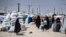 Families carry their belongings at the Kurdish-run Al-Khol camp, which holds relatives of suspected Islamic State fighters in Syria.