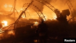 Кіеўскія ратаўнікі змагаюцца з пажарам на месцы ўдару расейскага дрону, 23 кастрычніка 2025 году