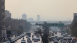 Traffic moves in heavy smog in Tehran on November 29, 2025. (Photo by ATTA KENARE / AFP)