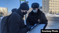 Полицейские предъявляют протокол активисту (архивное фото)