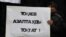 Қаңтар құрбандарын еске алу акциясында Қазақстан президенті Қасым-Жомарт Тоқаевтан азаптауды тоқтатуды талап еткен үндеу жазылған плакат ұстап тұрған адам. Алматы, 13 ақпан 2022 жыл.
