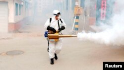 یک کارگر چینی در حال ضدعفونی کردن یکی از روستاها 