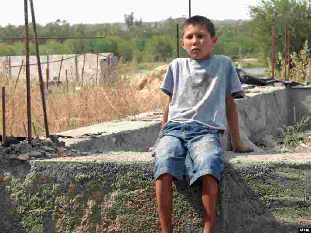 Кішкентай Санжар әжесінің  сүріліп тасталған үйінің іргетасын да қияр емес, Алматы, 16 қыркүйек, 2008 жыл    - Казахстан – Жилищный кризис. Мальчик Санжар сидит на руинах дома принадлежавший его бабушки .Микрорайон «Красный Трудовик». Almaty, 16Sep2008 