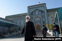 Men wearing face masks walk in Dushanbe on February 1 as the country reopened its mosques, which were shuttered for nine months, citing a "normalization" of the coronavirus situation.