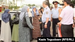 Полицейские не допускают к зданию прокуратуры жен узбекских беженцев-мусульман. Алматы, 9 июня 2011 года.  