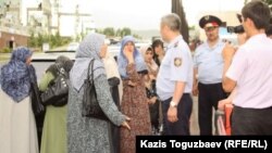 Полицейлер өзбек босқындарының әйелдерін прокуратура ғимаратына жібермей тұр. Алматы, 9 маусым 2011 жыл.  