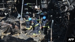 Співробітники ДСНС України розбирають завали у гіпермаркеті, зруйнованому внаслідок російського удару, Харків, Україна, 26 травня 2024 року 