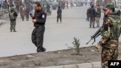 Afghan security forces stand guard after a gun attack in Kabul on March 6.