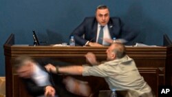 Алеко Элисашвили, который молча наблюдал за дебатами, подошел к трибуне и нанес прямой удар в голову Мамуке Мдинарадзе