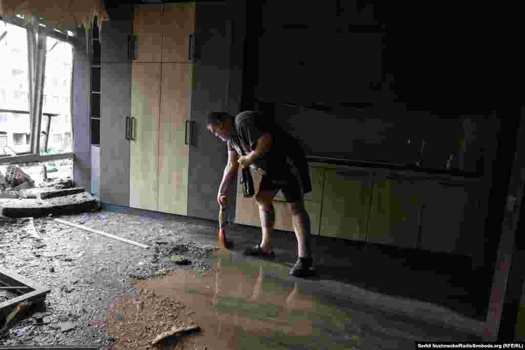 Житель цього будинку Вадим прибирає свою пошкоджену ударом квартиру