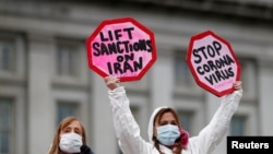 دو تن از معترضان در برابر کاخ سفید که خواستار لغو تحریم‌های آمریکا علیه ایران بودند