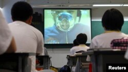 Кытай студенттерине космостогу учкуч  жандуу лекция окуп жатат. 