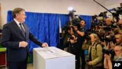 Кандидат у президенти Крін Антонеску посміхається ЗМІ, голосуючи в першому турі повторних президентських виборів у Бухаресті 4 травня 2025 року