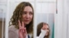 Katsyaryna Andreyeva and Daryya Chultsova, Belarusian journalists working for the Polish television channel Belsat, accused of coordinating mass protests in 2020 by broadcasting live reports, flash the victory sign at a court hearing in February 2021.