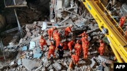 Куткаруучулар мейманкананын урандыларынын алдынан жабыркагандарды издеп жатышат. Кытай. 12-июль, 2021-жыл.