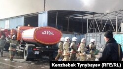 Сотрудники противопожарной службы прибыли к месту вспыхнувшего на рынке пожара. Алматы, 17 ноября 2013 года.