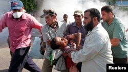 هواداران مرسی یکی از زخمی‌شدگان را از محل درگیری با ارتش، در برابر مقر گارد ریاست جمهوری، دور می‌کنند