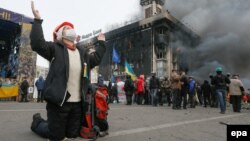 Украина -- Антиөкмөттүк демонстрацияга катышып жаткан бир аял Жаратканга жалбарып жатат. Киев, 19-февраль, 2014.