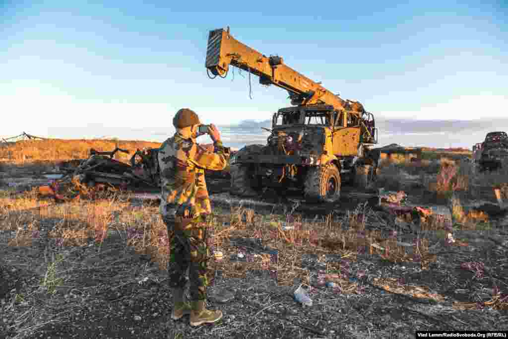 Волонтер Юрій фотографує кран, зруйнований від обстрілів​