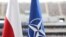 Флаг Польши и флаг НАТО перед Национальным стадионом в Варшаве, где проходит саммит. 8 июля