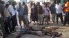 Жители сомалийского города Могадишо стоят возле тел двух погибших горожан. Иллюстративное фото.       