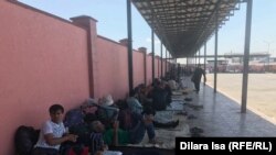 Застрявшие в Казахстане таджикские мигранты на автовокзале на территории Туркестанской области близ границы с Узбекистаном. 2 июня 2020 года.
