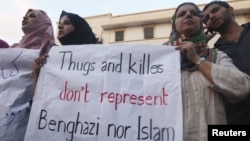 Ливиялык демонстранттар Бенгазидеги АКШ консулдугуна кол салуу кезинде Кошмо Штаттардын элчсинин өлтүрүлүшүн айыптаган плакаттарды кармап турушат. 12-сентябрь 2012