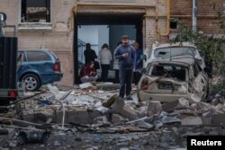 Люди возле пострадавшего здания в Киеве, Украина, 28 августа 2025 года