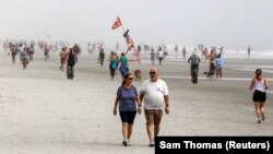 Жэксонвилл пляжында эс алып жаткан адамдар.  Флорида, АКШ. Июнь, 2020-жыл.