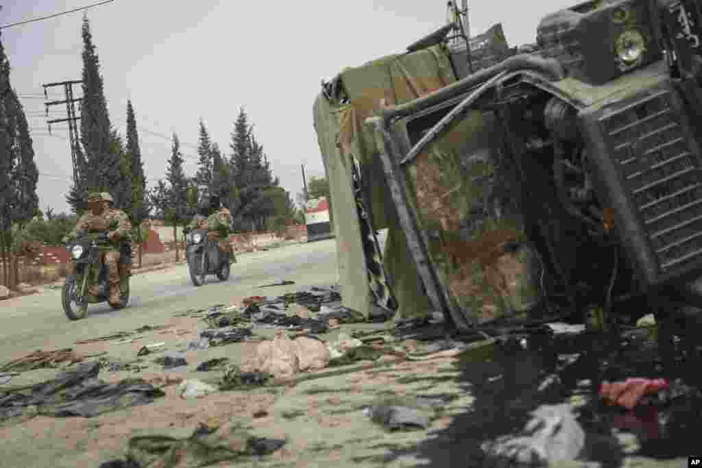 شورشیان در حال عبور از کنار یک خودروی آسیب&zwnj;دیده دولتی در جنوب حماه، سوریه، در ۷ دسامبر ۲۰۲۴ دیده می&zwnj;شوند.