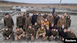 Ukrainian prisoners of war pose after a swap in the Zaporizhzhya region on November 24.